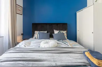 a blue bedroom with a large bed with blue walls at Chambre de luxe MADRID a LIEGE Sale de bain privée 1er étage check in autonome cuisine partagée in Liège