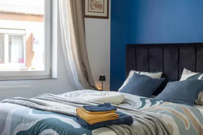 a blue bedroom with a bed with towels on it at Chambre de luxe MADRID a LIEGE Sale de bain privée 1er étage check in autonome cuisine partagée in Liège