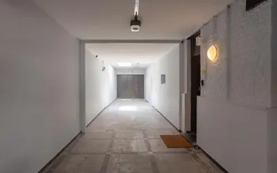an empty hallway with white walls and a door at Chambre de luxe MADRID a LIEGE Sale de bain privée 1er étage check in autonome cuisine partagée in Liège