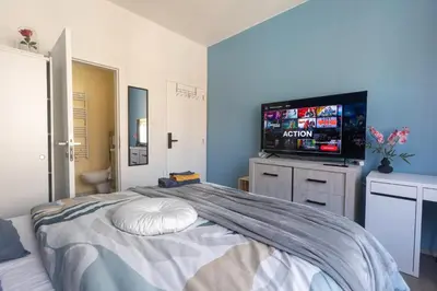 a bedroom with a bed with a flat screen tv at Chambre de luxe MADRID a LIEGE Sale de bain privée 1er étage check in autonome cuisine partagée in Liège