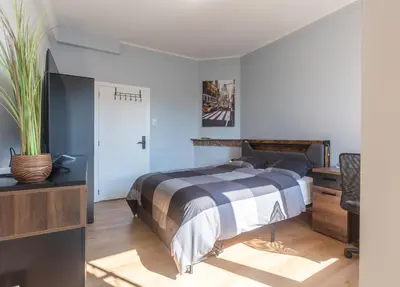 a bedroom with a bed and a desk and a tv at Chambre New York à Liège Moderne avec salle de bain privée spacieuse, check in autonome, 2eme etage in Liège