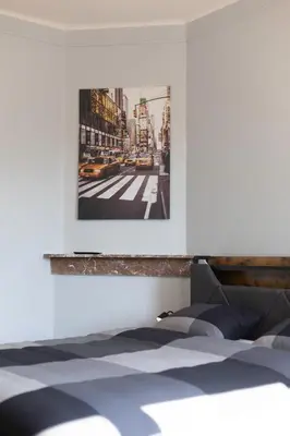 a bedroom with a bed with a picture on the wall at Chambre New York à Liège Moderne avec salle de bain privée spacieuse, check in autonome, 2eme etage in Liège