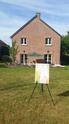 a sign in the grass in front of a house at Le Grand Jardin in Dalhem