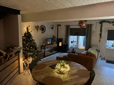 a living room with a christmas tree and a table at La maison de MiLy in Bassenge