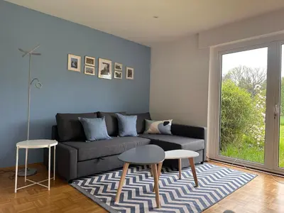 a living room with a couch and two tables at Johannisbeere in Raeren