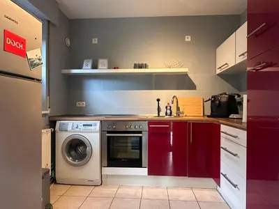 a kitchen with red cabinets and a washing machine at Johannisbeere in Raeren