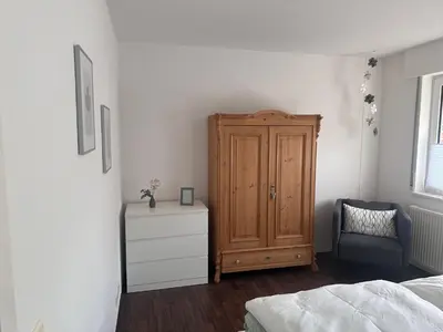 a bedroom with a wooden cabinet and a bed at Johannisbeere in Raeren