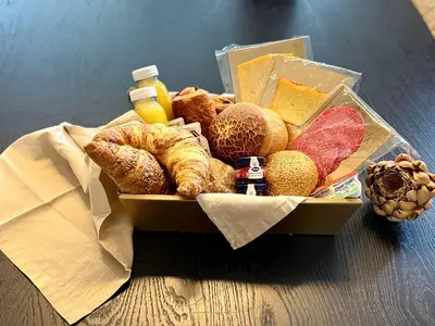 a box filled with different types of bread and cheese at Aurora City Apartment in Lommel