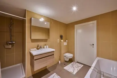 a bathroom with a sink and a tub and a toilet at Aurora City Apartment in Lommel
