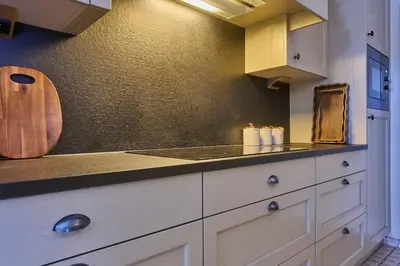 a kitchen with white cabinets and a counter top at Aurora City Apartment in Lommel