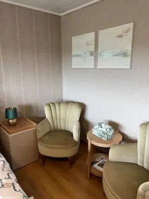 a living room with a chair and a table at 't Steenenhuys in Dilsen-Stokkem