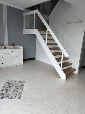 a white staircase in a room with a dresser at 't Steenenhuys in Dilsen-Stokkem