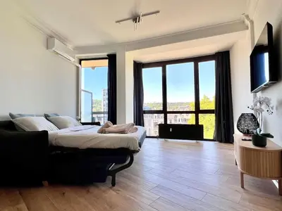 a bedroom with a large bed and large windows at Cozy and fully equipped in the center of Liege 4 guests in Liège