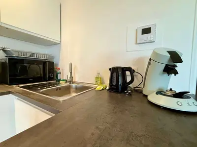 a kitchen counter with a coffee maker and a microwave at Cozy and fully equipped in the center of Liege 4 guests in Liège