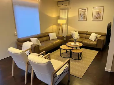 a living room with a couch and a table and chairs at Casa Sahara - 8 guests - near nature reserve in Lommel