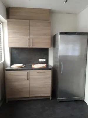 a kitchen with a stainless steel refrigerator and wooden cabinets at Casa Sahara - 8 guests - near nature reserve in Lommel