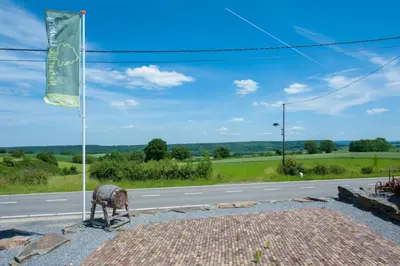 a horse on the side of a road next to a flag at Camping Natuurlijk Limburg - Chalet 4 in Voeren
