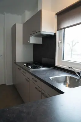 a kitchen with a sink and a window at Camping Natuurlijk Limburg - Chalet 4 in Voeren