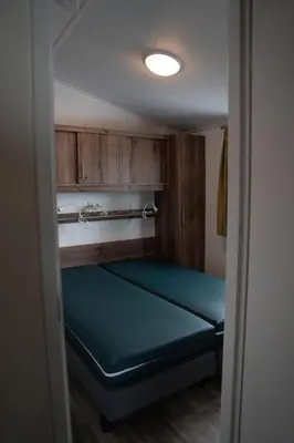 a small room with a bed in a room at Chalet - Camping Natuurlijk Limburg in Voeren