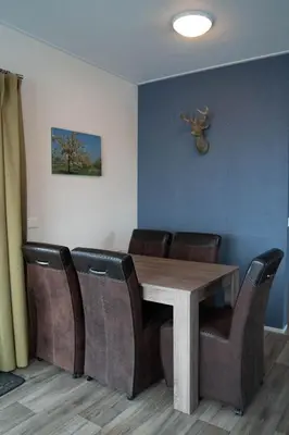 a dining room with a wooden table and chairs at Chalet - Camping Natuurlijk Limburg in Voeren