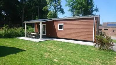 a smallshed with a picnic table in a yard at Chalet - Camping Natuurlijk Limburg in Voeren