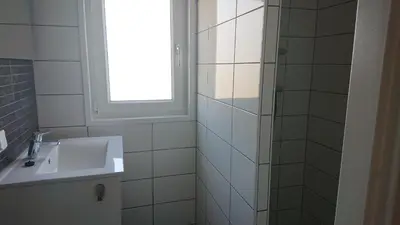 a white bathroom with a sink and a window at Chalet - Camping Natuurlijk Limburg in Voeren
