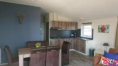 a kitchen and living room with a table and a dining room at Chalet - Camping Natuurlijk Limburg in Voeren