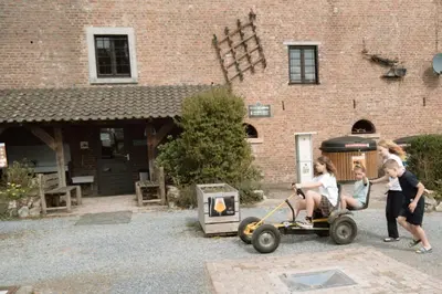 a group of children playing with a toy tractor at Camping Natuurlijk Limburg - Appartement in Voeren