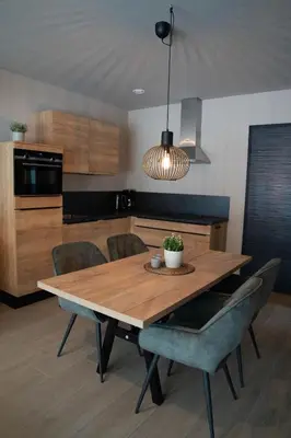 a kitchen with a wooden table and chairs at Camping Natuurlijk Limburg - Appartement in Voeren