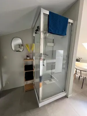 a shower with a blue curtain in a room at Studio SC - Cozy appartement in Genk near Thor Park - 4 people in Genk