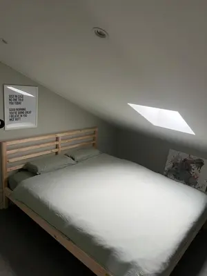 a bedroom with a large bed with a skylight at Studio SC - Cozy appartement in Genk near Thor Park - 4 people in Genk