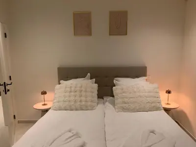 a bed with white sheets and pillows in a room at Inspire Residence and private Wellness in Tongeren