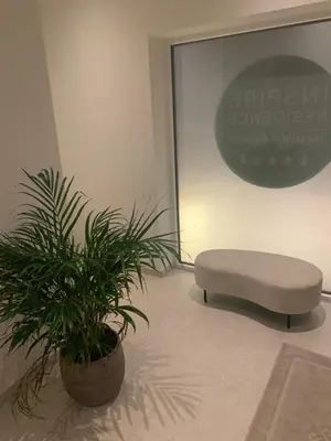 a white ottoman and a plant in a room at Inspire Residence and private Wellness in Tongeren