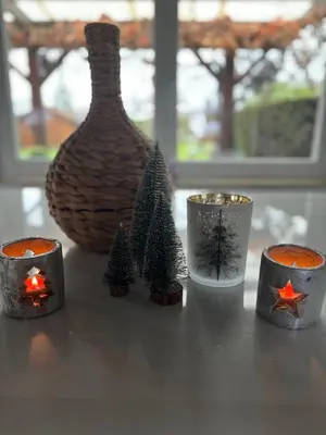 a table topped with christmas candles and a vase at Villa les Hauts de Heusy in Verviers