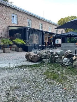 a building with rocks in front of a building at La Luna in Lanaken