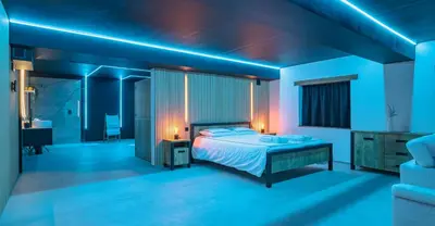 a bedroom with a bed with blue lights on it at Suite Ôna in Bassenge