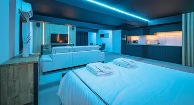 a blue room with a bed and a kitchen at Suite Ôna in Bassenge