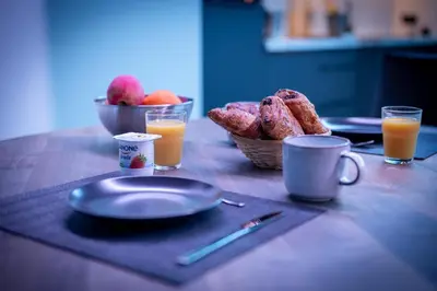 a table with plates of food and two glasses of orange juice at Suite Ôna in Bassenge