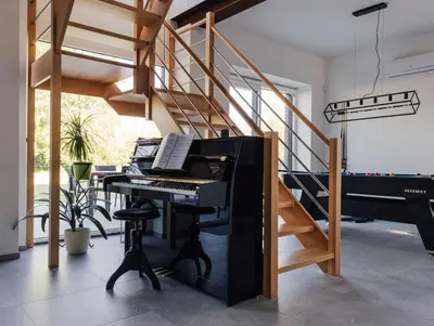 a room with a piano and a staircase at Le Surdan in Bassenge