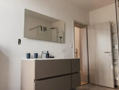 a kitchen with a sink and a mirror on the wall at Le Surdan in Bassenge