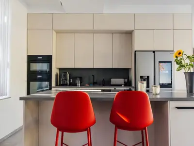a kitchen with two red chairs at a counter at Le Surdan in Bassenge