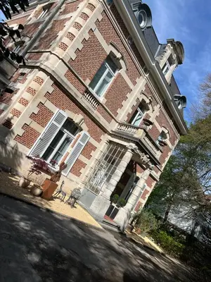 a large brick building with windows and a balcony at Chez Léopold in Verviers