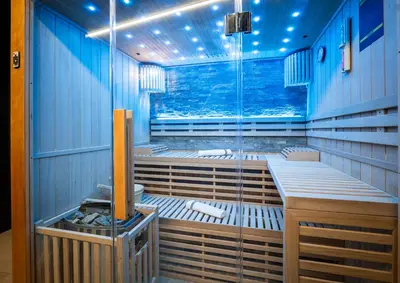 a sauna with blue walls and a large window at Suite Soma in Bassenge