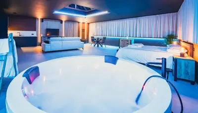 a large room with a bed and a living room at Suite Soma in Bassenge