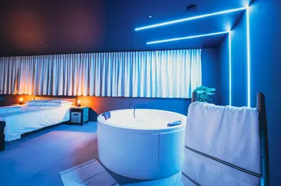 a large bathroom with a tub and a bed at Suite Soma in Bassenge