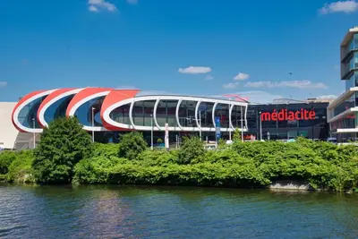 a large building with a stadium in front of the water at Urban Cocoon in Liège