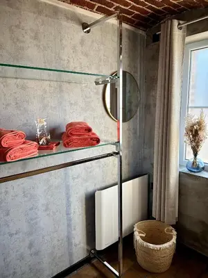 a bathroom with a shower with red towels on a shelf at Studio 94 in Welkenraedt