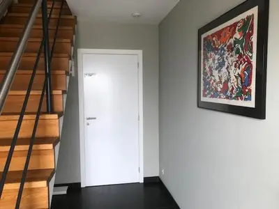 a hallway with a white door and a painting on the wall at Fokus time out 2 in Dessel