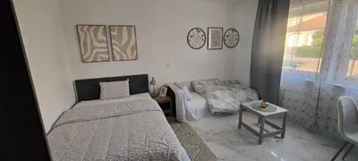 a small bedroom with a bed and a couch at Studio spacieux ,chaleureux et cosy in Heers