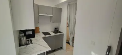 a kitchen with white cabinets and a counter top at Studio spacieux ,chaleureux et cosy in Heers